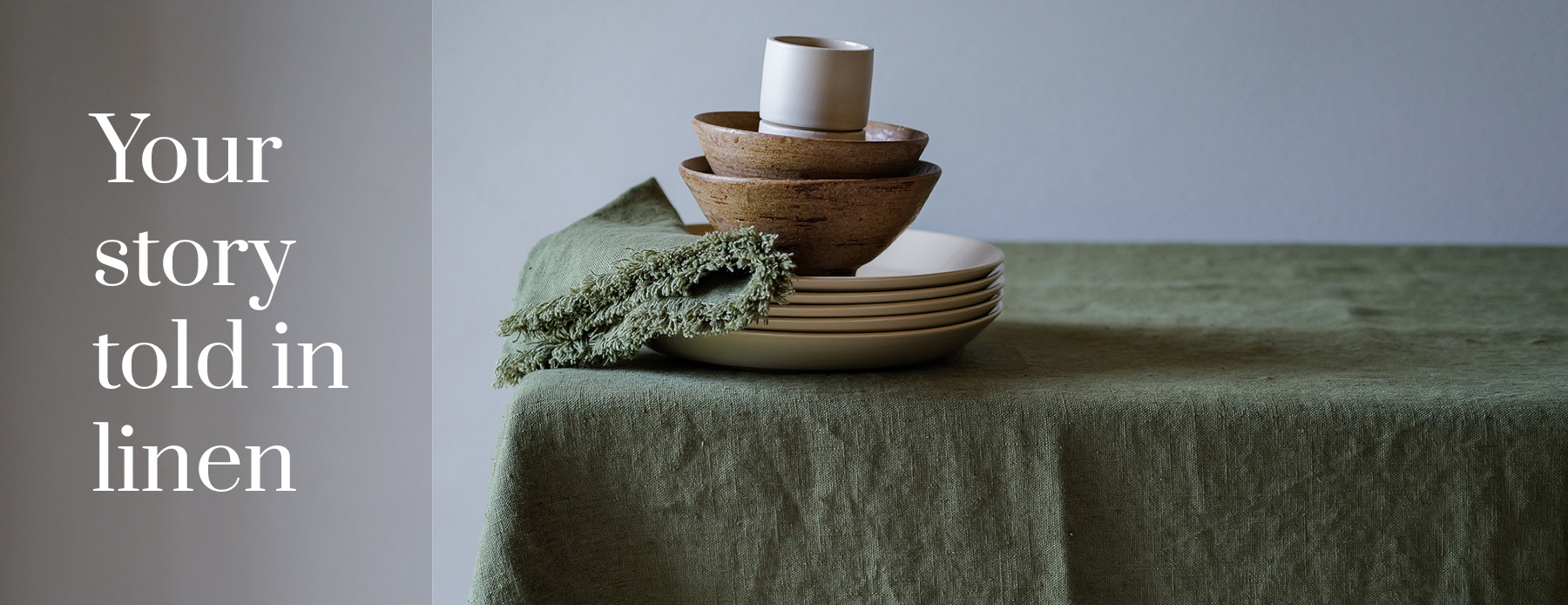 Your story told in linen — green linen tablecloth and fringed napkins with ceramic bowls.