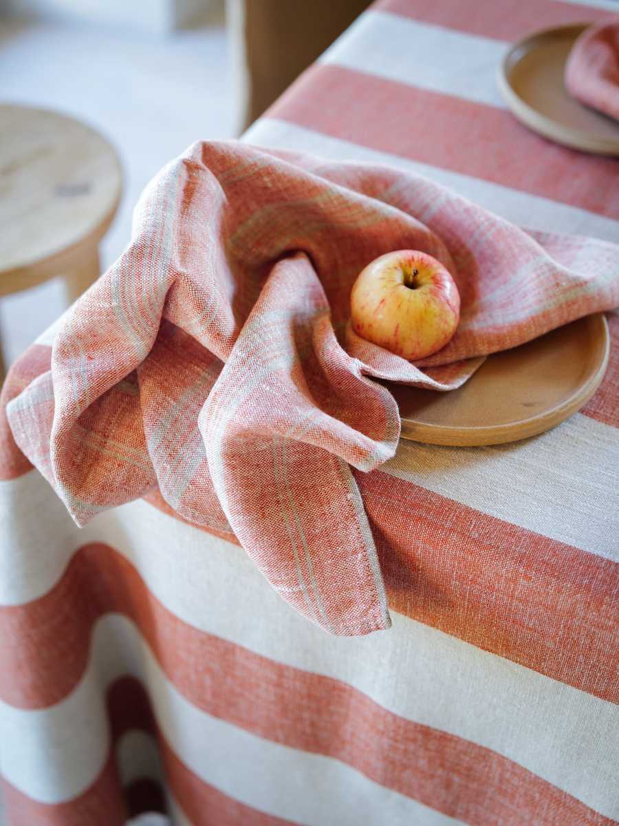 Brick striped linen napkin with an apple on a beige plate