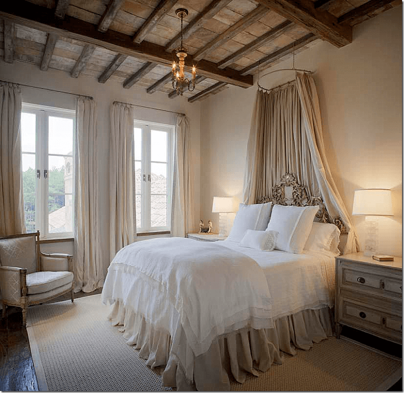 White bed surrounded by a softly draped linen canopy
