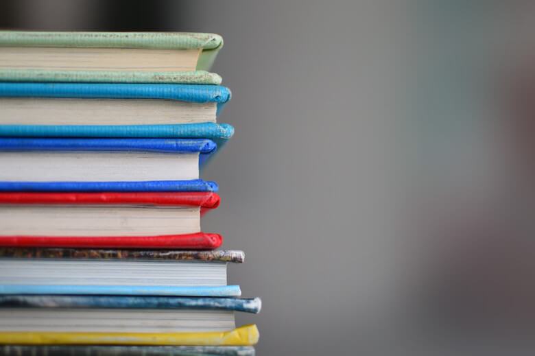 Pile de livres reliés en toile illustrant l'usage du lin en reliure