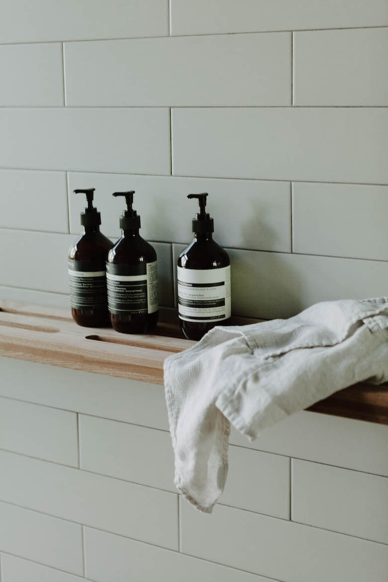 Folded linen textiles in the modern Birch Le bathroom and laundry area