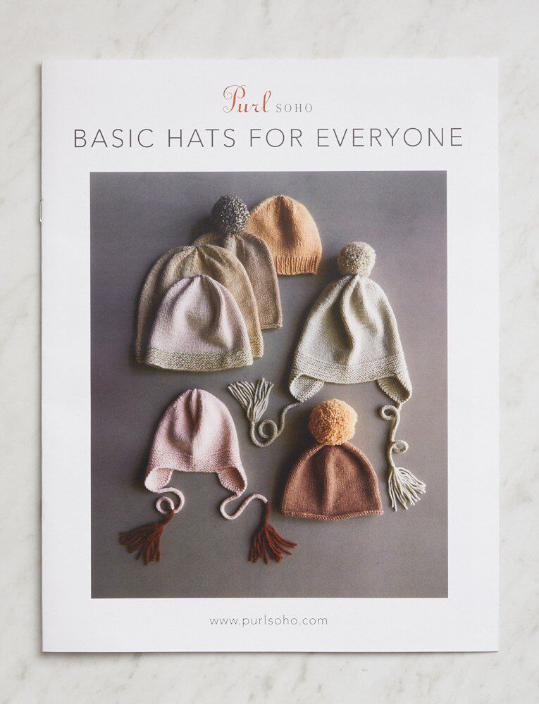 Five hand-knitted baby hats in different styles