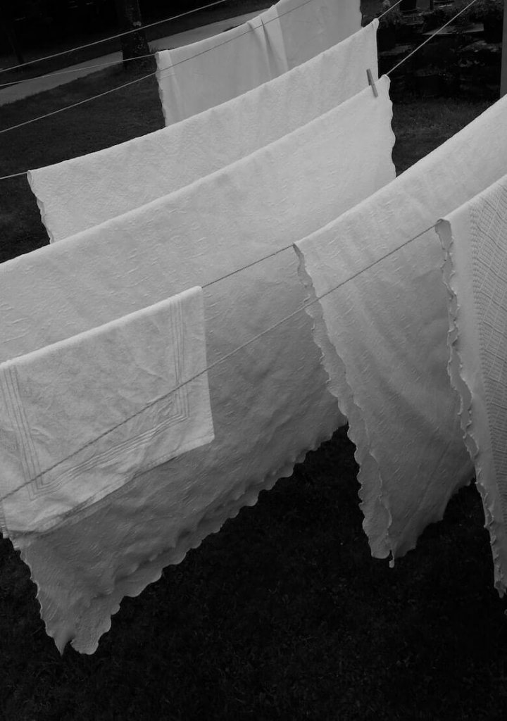 Antique linen textile being inspected before gentle cleaning
