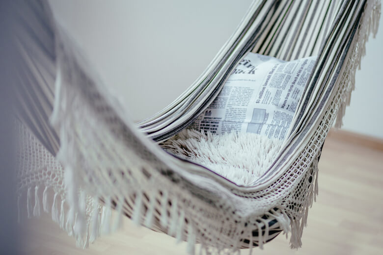 Hammock and linen bedding in an airy summer bedroom