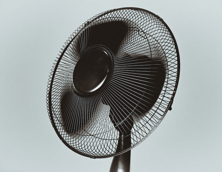 Fan circulating air in a bedroom on a hot night