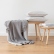 Grey merino wool throw styled on a light wooden chair